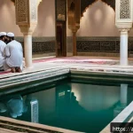 이란의 장례 절차 - A solemn and respectful scene depicting the Islamic ritual of ghusl and kafan preparation for a dece...